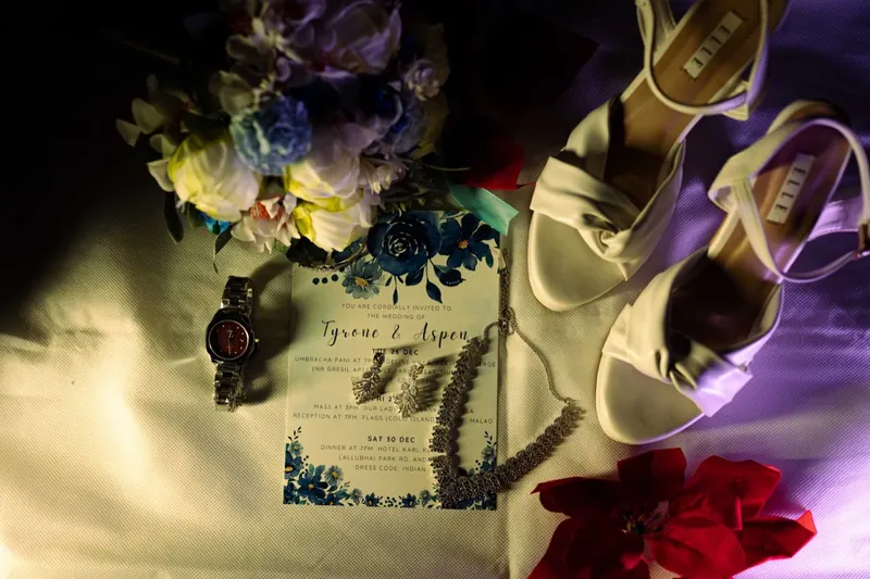 Wedding invitation, jewellery and bridal details arranged together